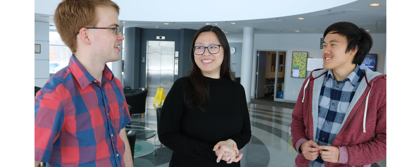 (right) Mindren Lu and (left) Trevor Spreadbury stand with their mentor (middle) Maria Chan
