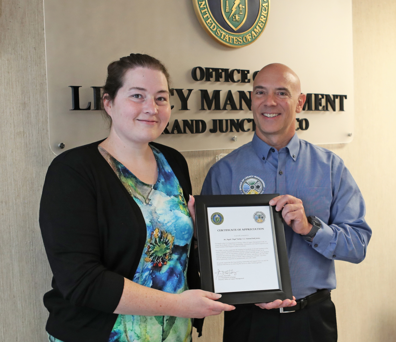 LM Office Manager Paul Kerl presents Angel Barker with a plaque
