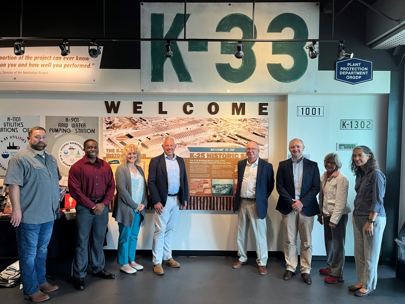 Pictured from left at the K-25 History Center are Jimmy Hughes, UCOR; Lanre Akande, intern with the EM Office of Regulatory and Policy Affairs; Joanna Hardin, Oak Ridge Office of Environmental Management; Alan Cumming, United Kingdom’s Nuclear Decommissioning Authority (NDA); Kent Fortenberry, UCOR; Gareth Taylor, NDA; Nancy Buschman, EM Office of Regulatory and Policy Affairs; and Nathalie Schmidt, UCOR. The visitors from the NDA learned about Oak Ridge’s history, including the completion of EM’s major cle
