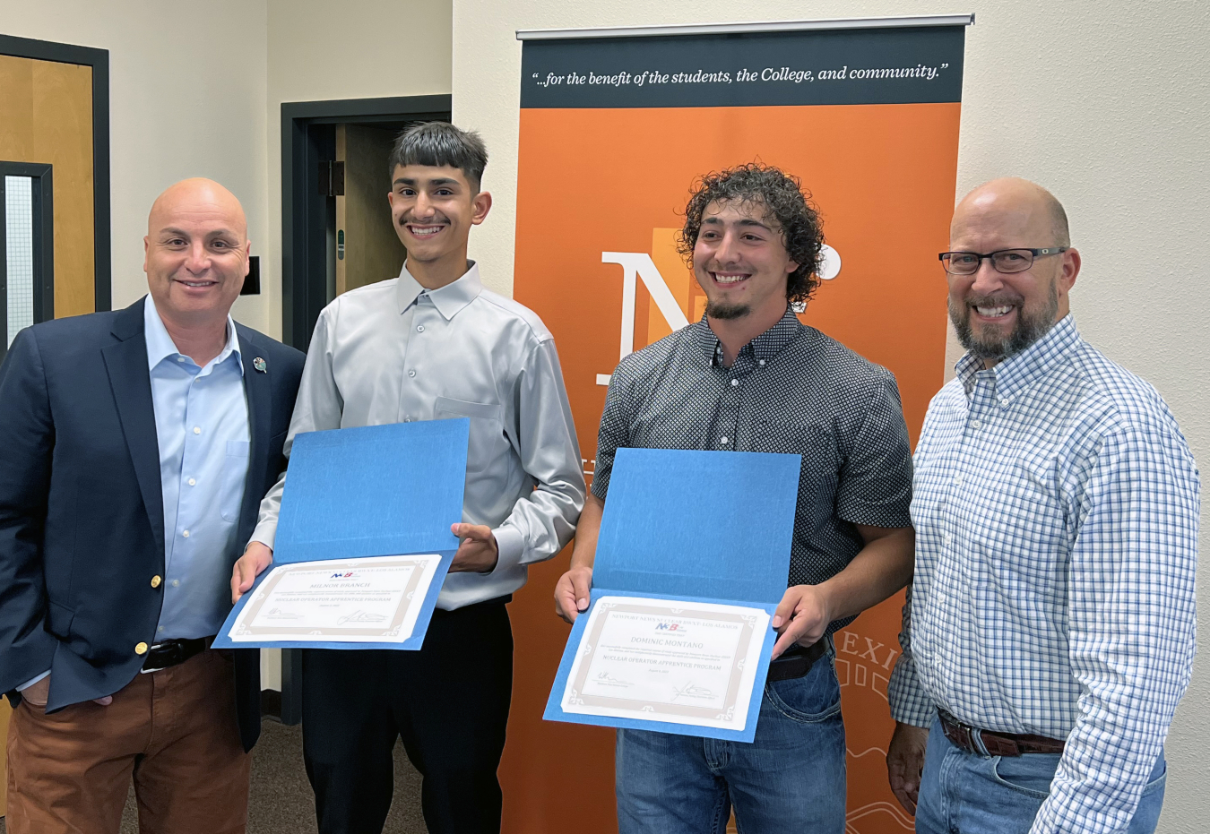 From left: Hector Balderas, Northern New Mexico College president; Milnor Branch; Dominic Montaño; and Brad Smith, Newport News Nuclear BWXT Los Alamos (N3B) president and general manager. Branch and Montaño are pictured holding their certificates of completion for the two-year N3B Nuclear Operator Apprenticeship Program.
