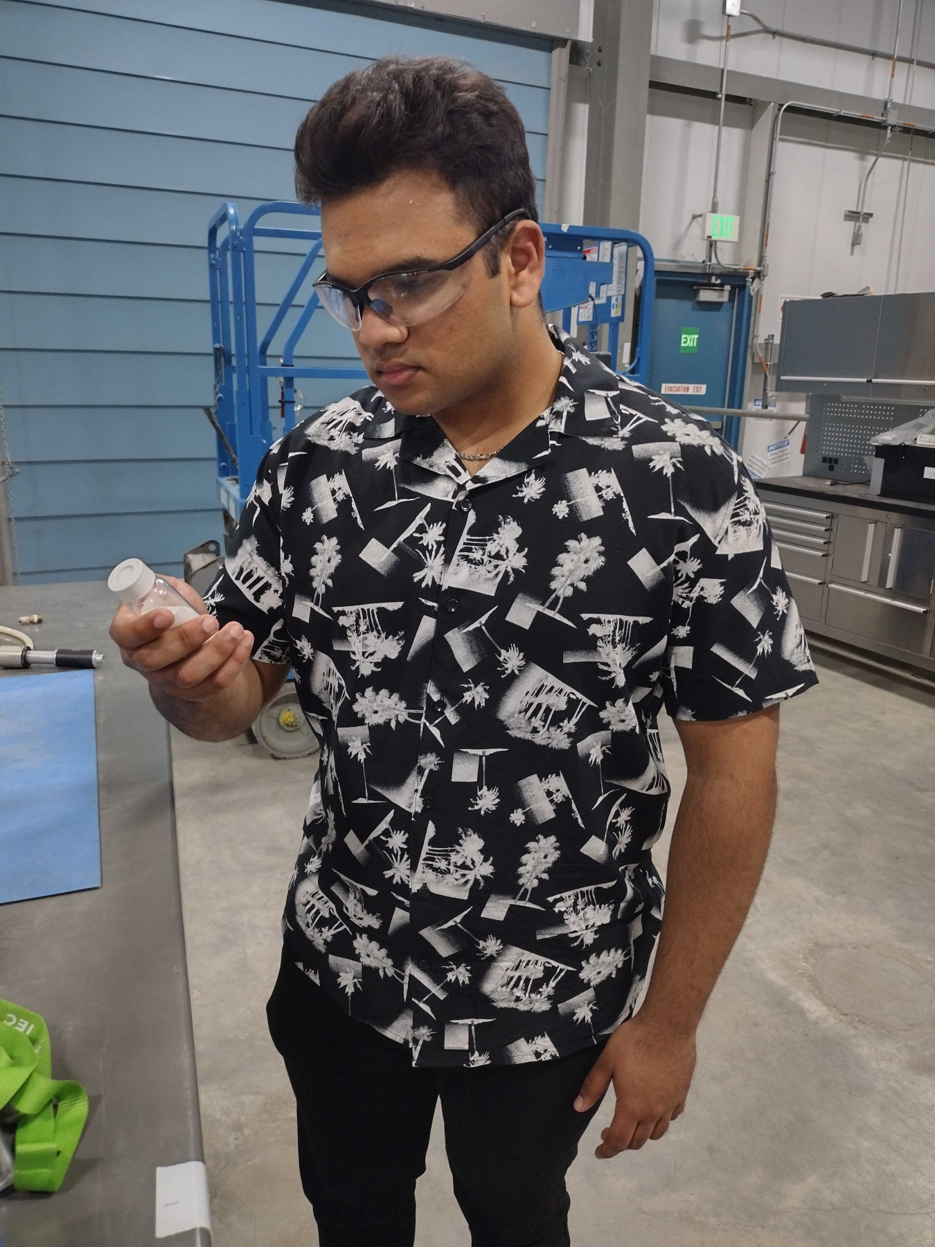 At the former Fuel Reprocessing Restoration Facility, the site of a full-scale calcine bin set mockup, Idaho Environmental Coalition intern Rajit Nilkar inspects the calcine simulant used for testing retrieval equipment developed by the project’s engineers.