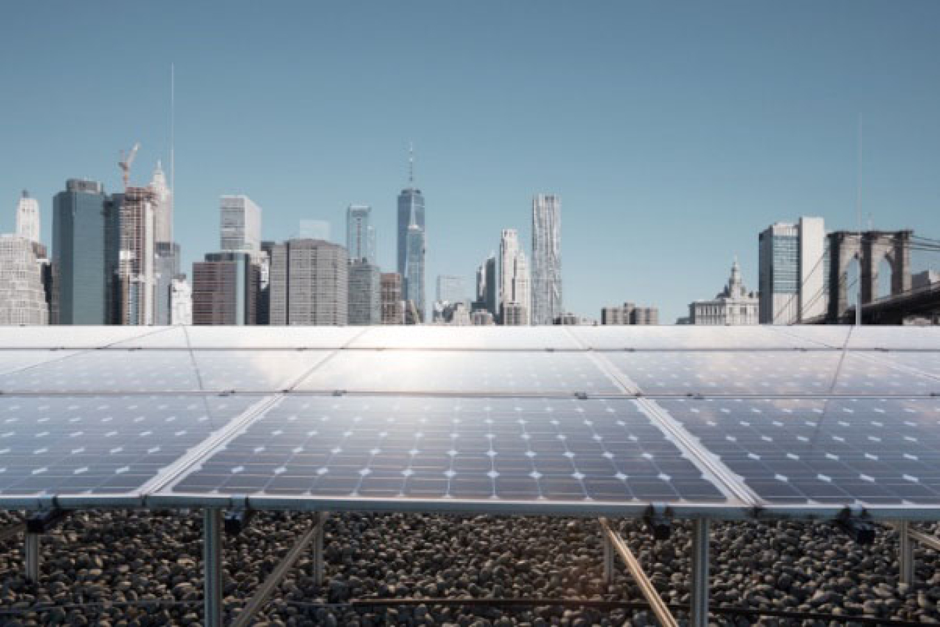 Solar panels in foreground with city skyline in background
