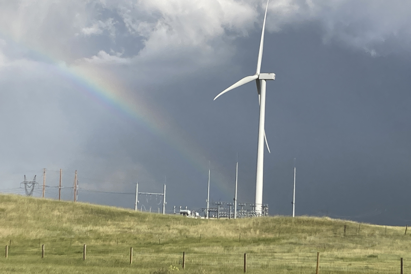 A wind turbine with a rainbow behind it