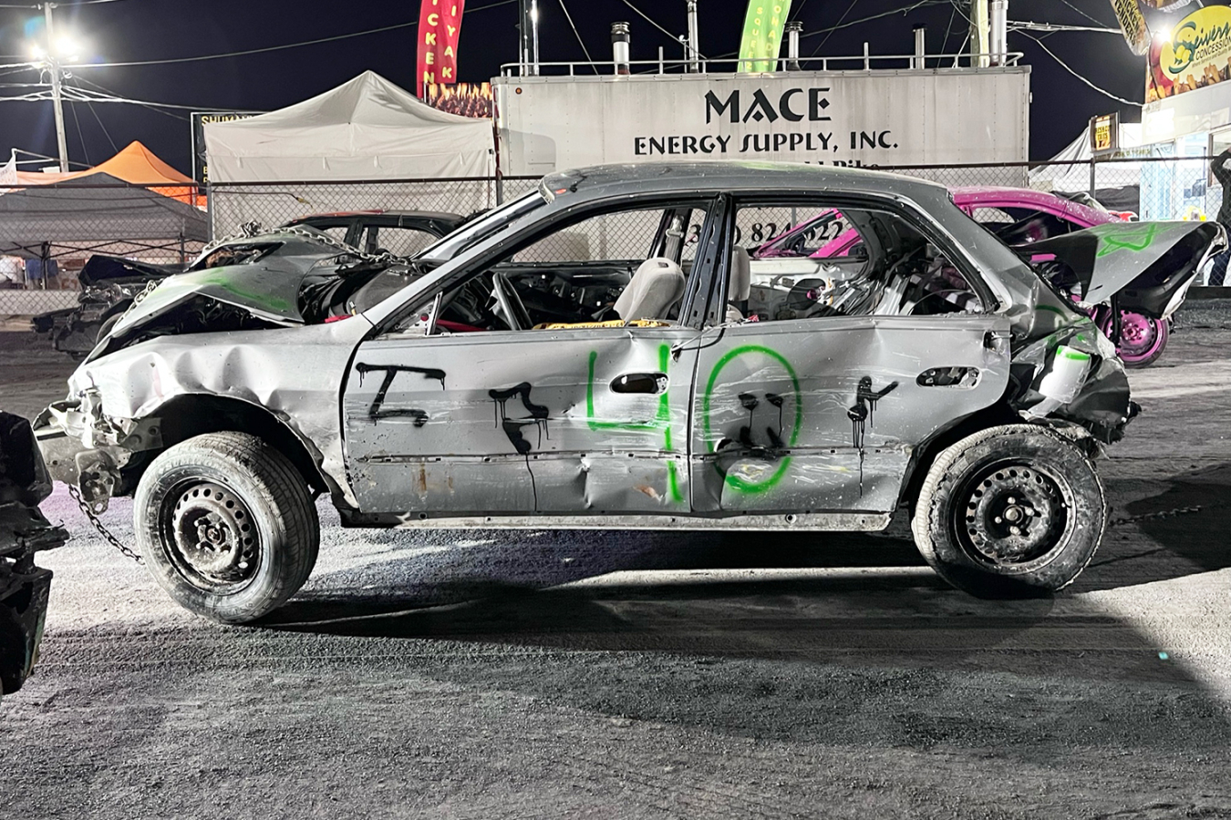 A wrecked car on a demolition derby track.