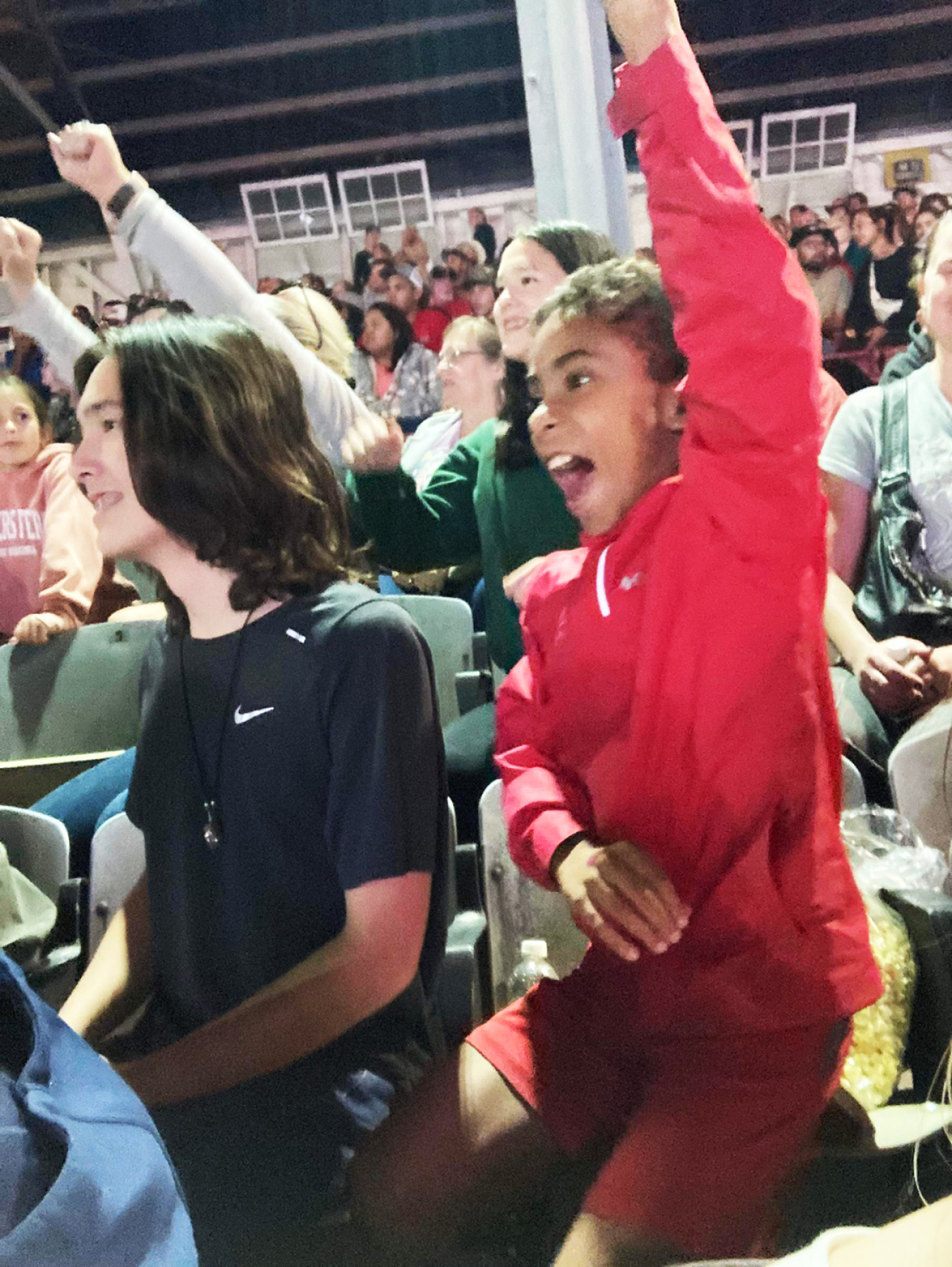 Young people cheer in grandstands.