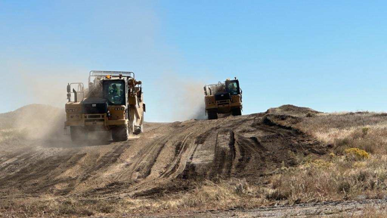 Heavy equipment trucks on engineered landfill.