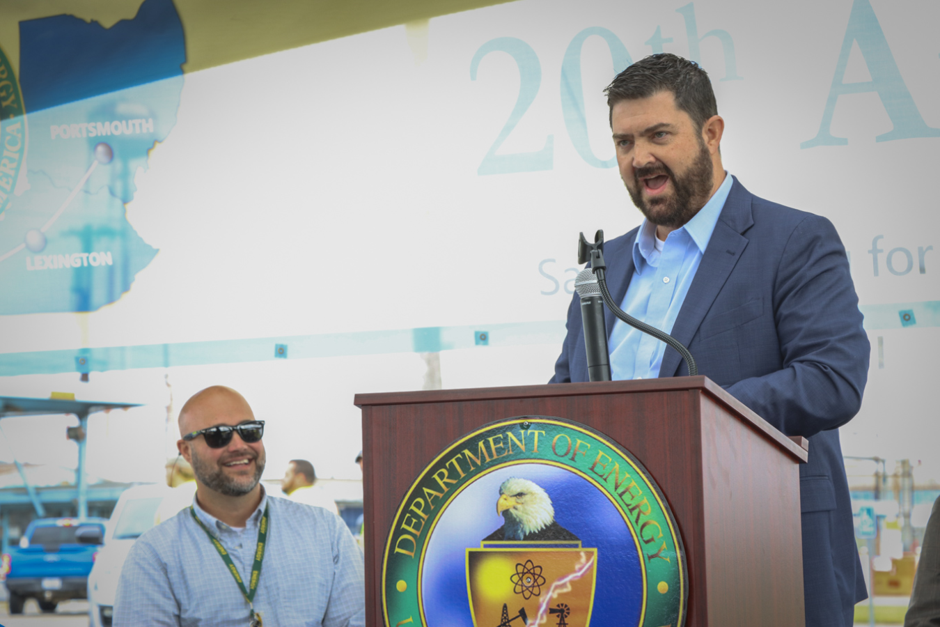Man in suit speaking at podium during an event
