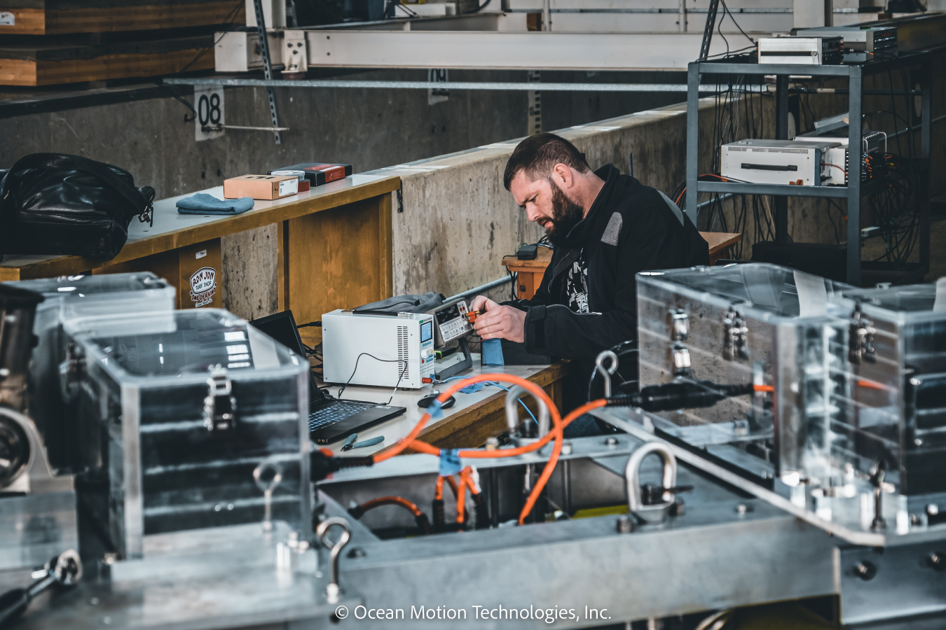 An individual working with wires attached to machinery.