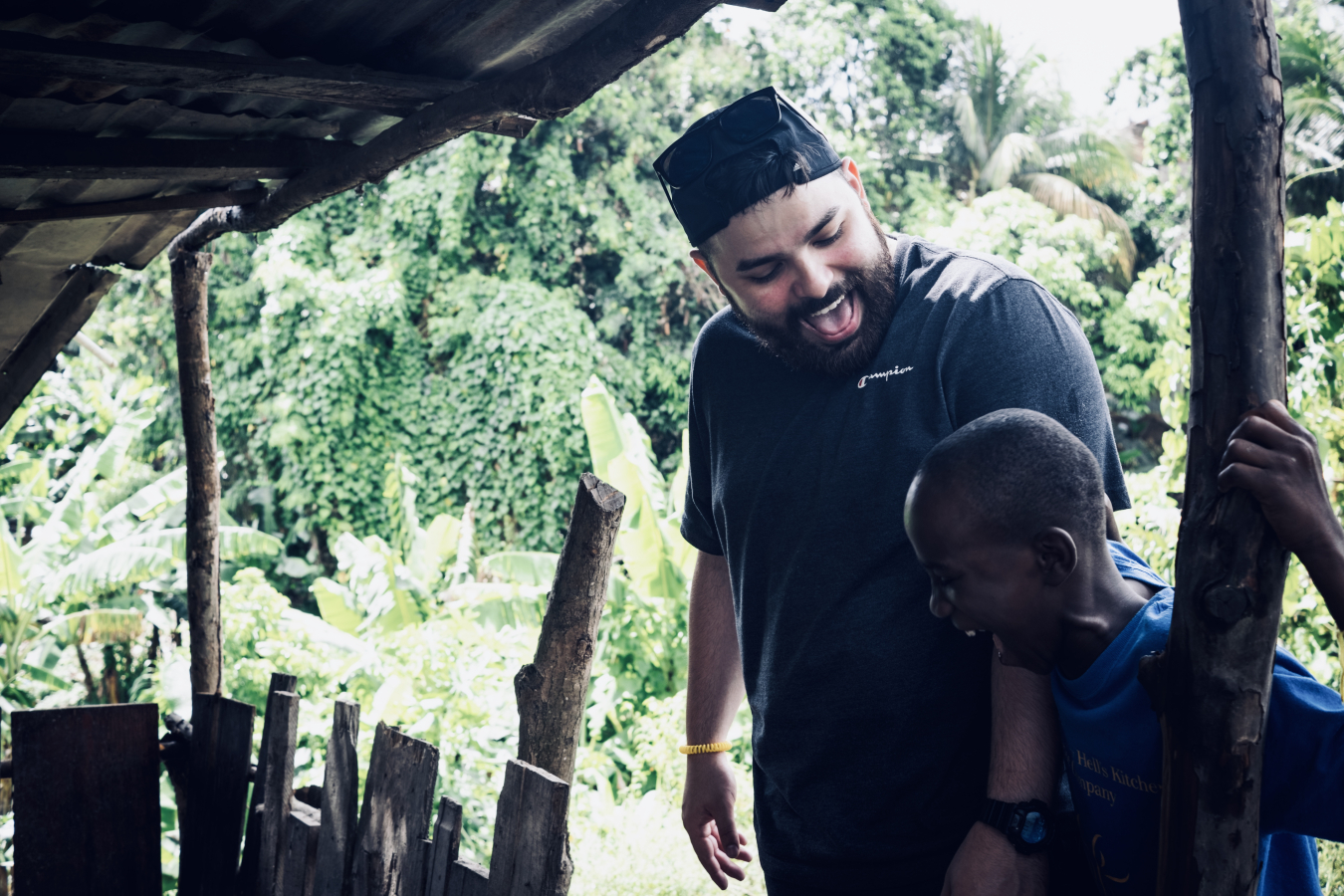 A man looks down at a child standing next to him.