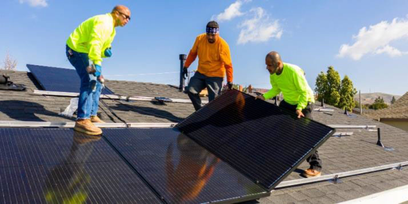 Team installs solar panels on roof
