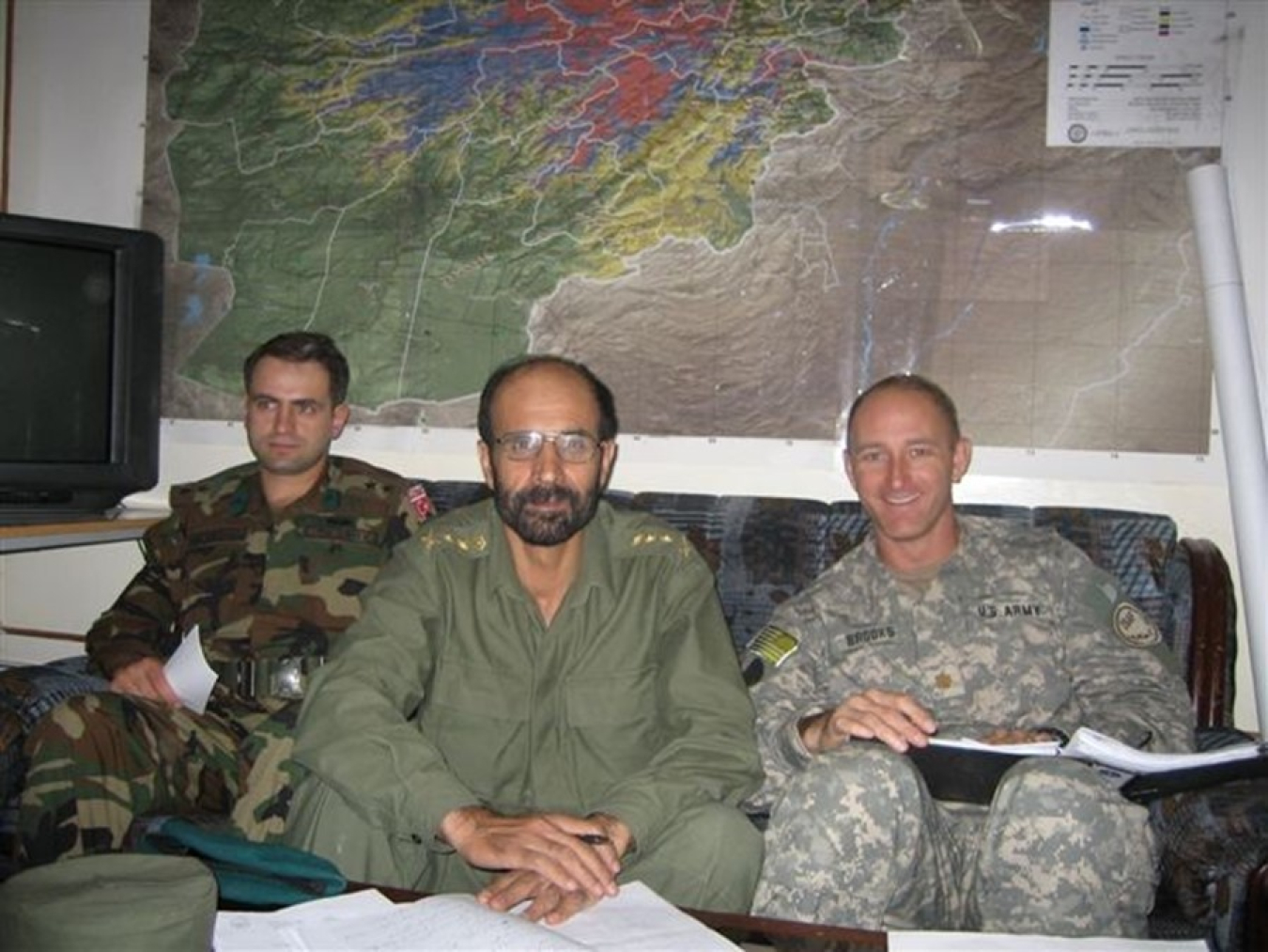 A photo of Andrae Brooks, right, and two of his international colleagues dressed in uniform.