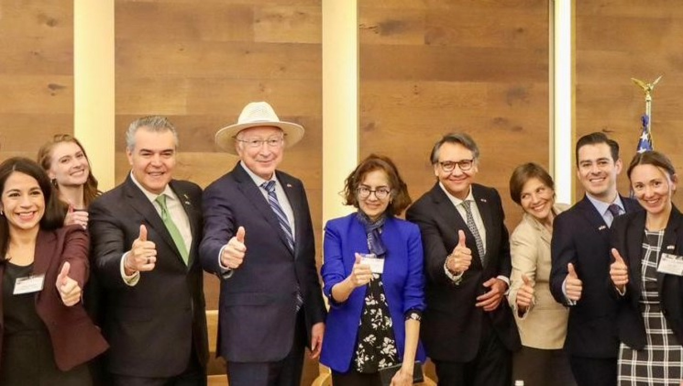 A group of seminar attendees giving a thumbs-up gesture