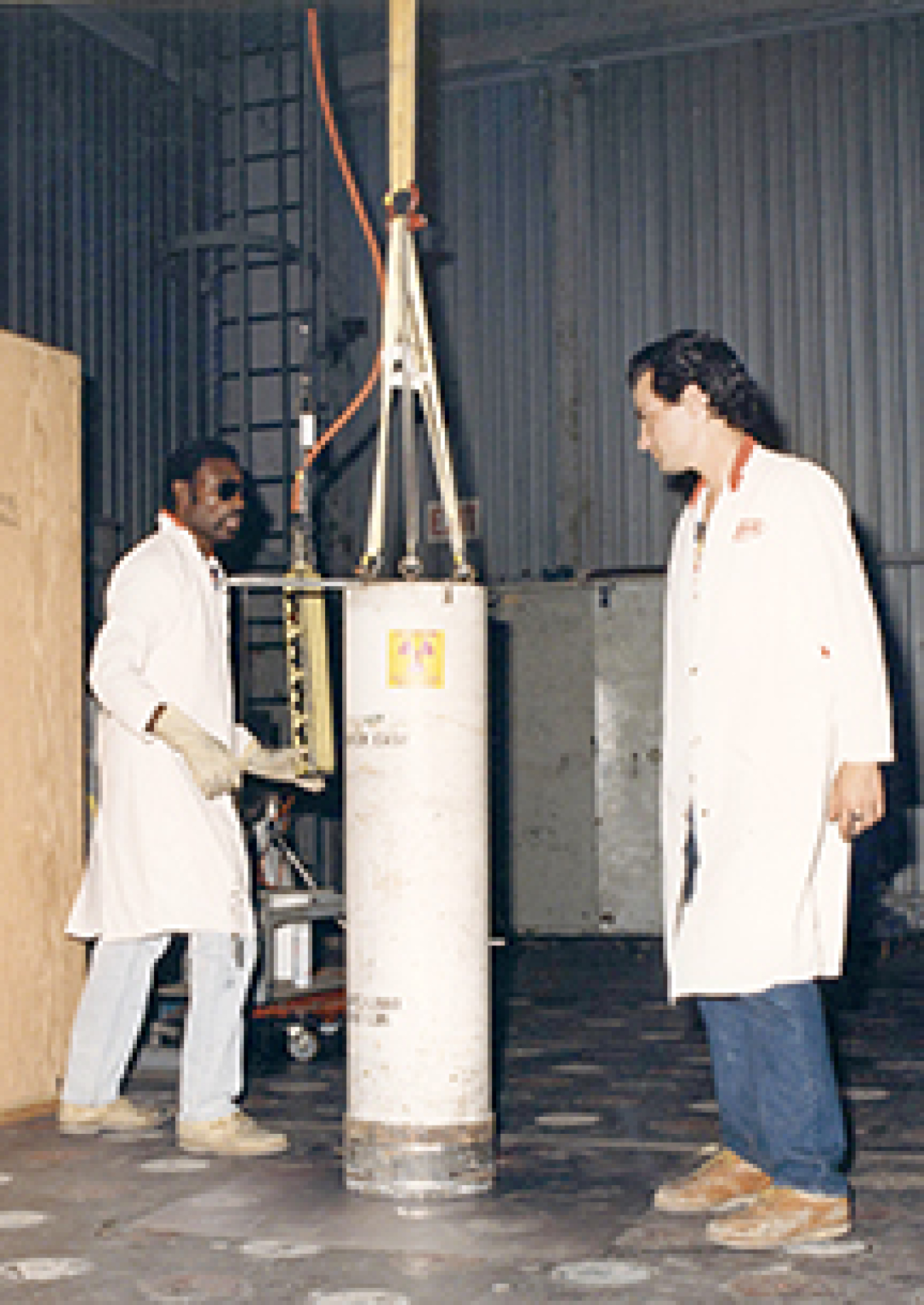 RMHF Personnel transferring fuel at Building 4022. Placing the shielded cask over the shielded vaults and using a crane to raise or lower the fuel inside minimized personnel exposure to radiation.