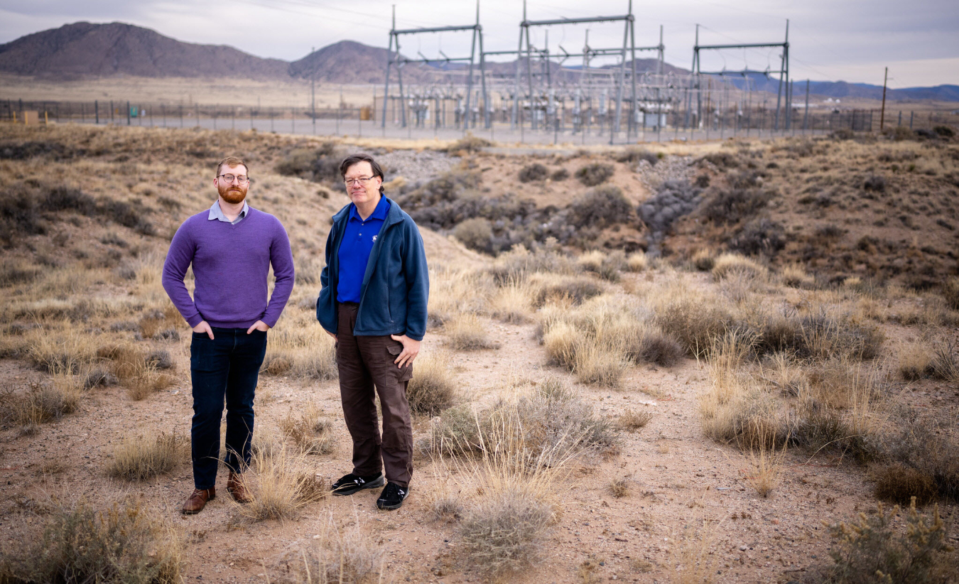 two men standing in desert field