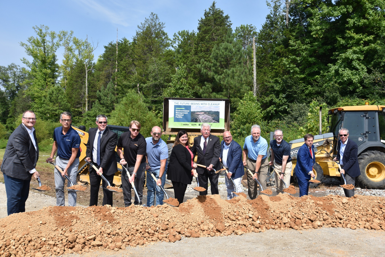 A group of people shovel to signify "breaking ground" at a facility