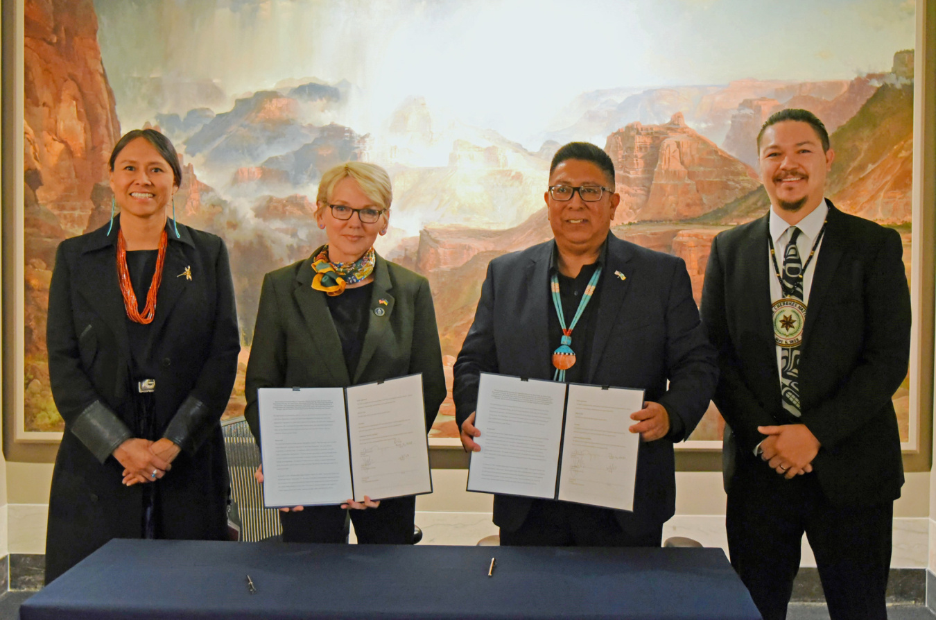 Officials from the U.S. Department of Energy and the Chairman of the Hopi Tribe pose at a MOU signing ceremony holding the signed documents.