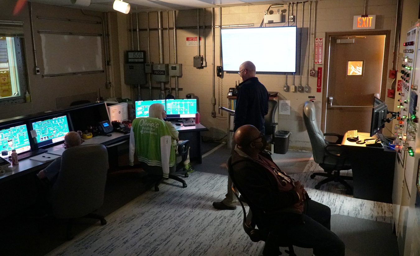 A dark control with lots of computers and four employees
