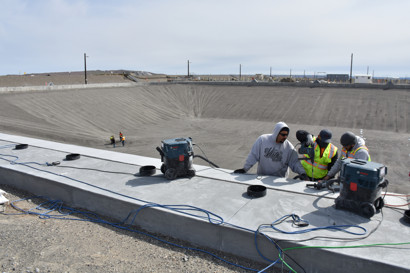 Employees install bolts onto a retention basin