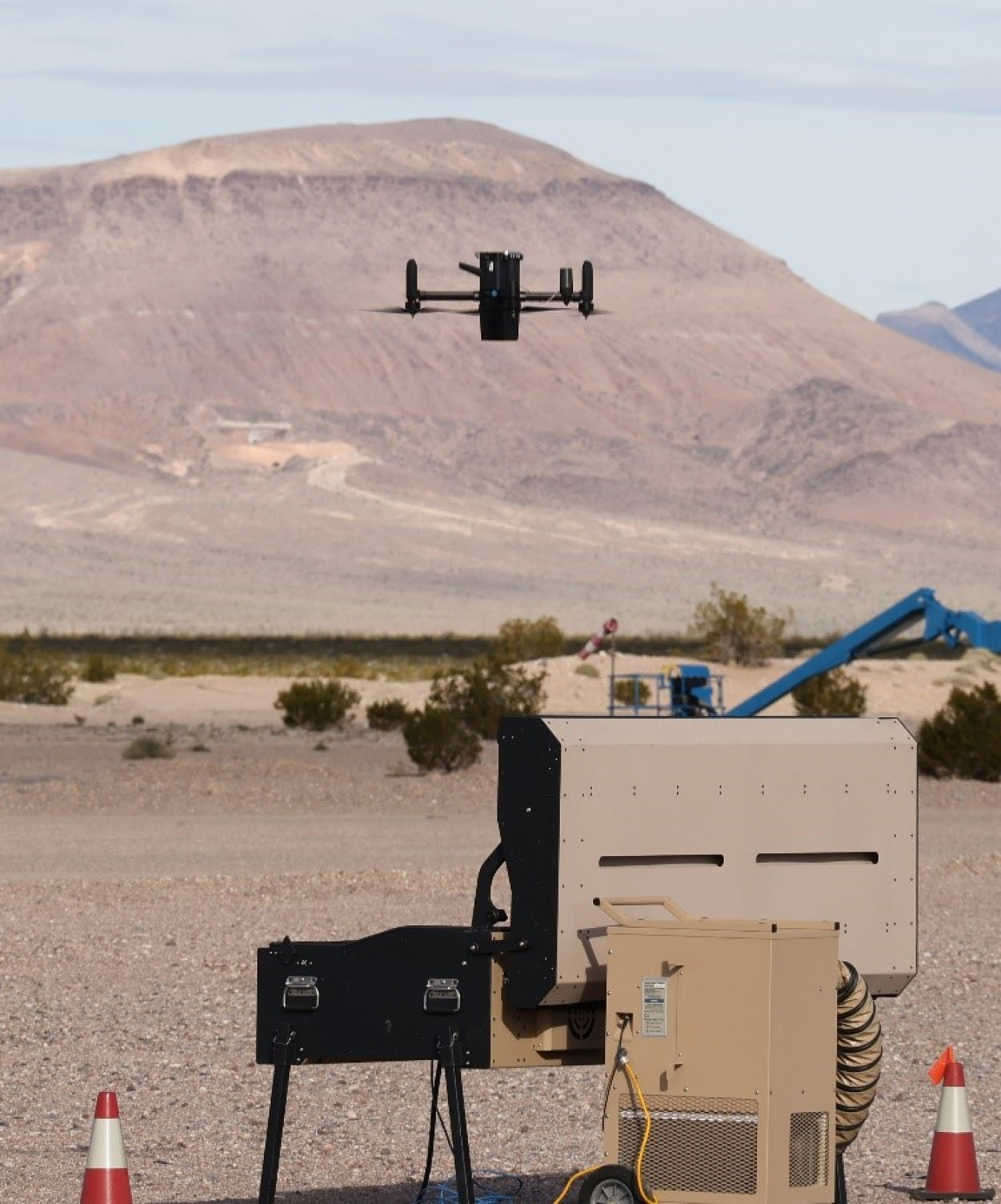 A black counter-UAS drone flying over a desert landscape during the demonstration at NNSS