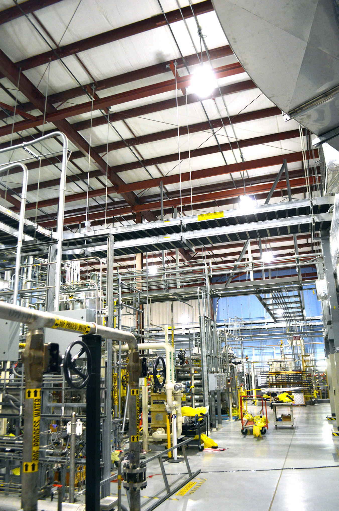 A wharehouse room of equipment with bright LED lights in the ceiling.