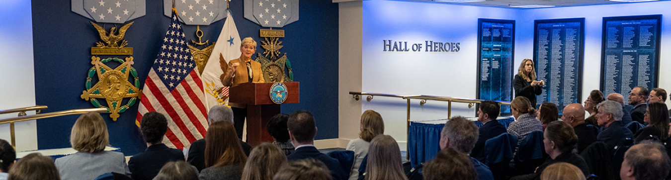 U.S. Secretary of Energy Jennifer Granholm speaking at a podium in front of an audience.