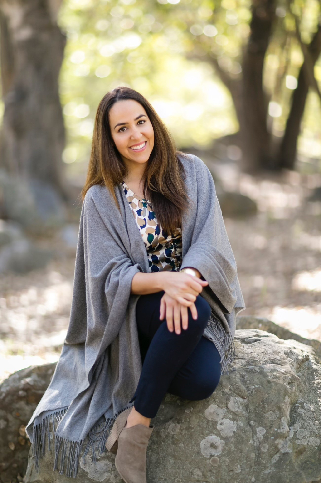 A professional photo of a woman sitting on a rock