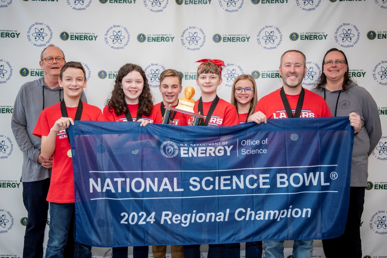 Middle school students holding up a banner for winner a science bowl