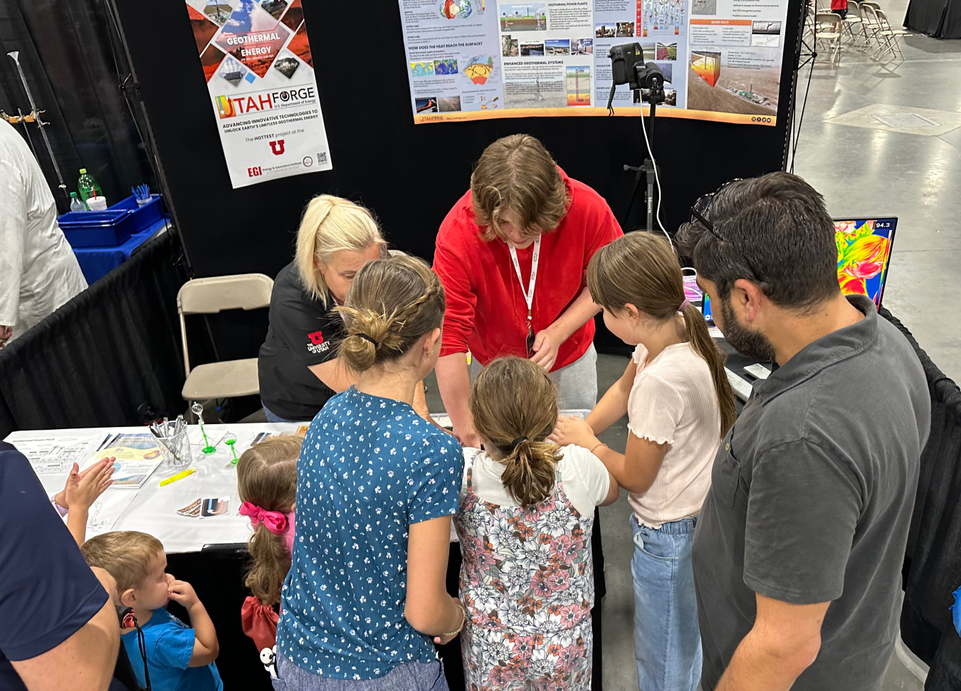 Utah FORGE's Gosia Skowron and University of Utah’s Chemical Engineering student Tyler Ray Owens demonstrate a Peltier module at Utah FORGE's crowded booth during STEMFest.