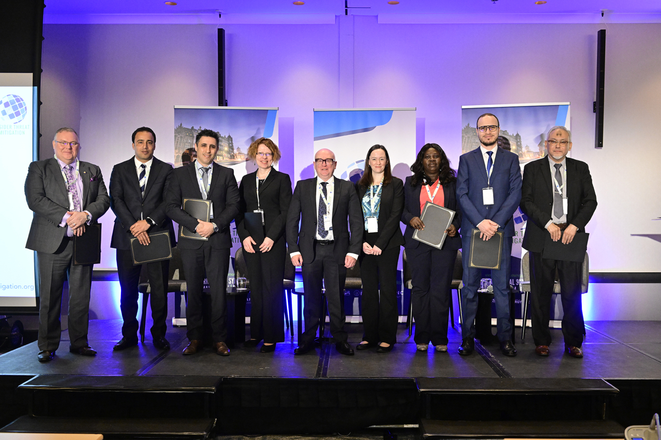 A group of presenters pose for a photo.