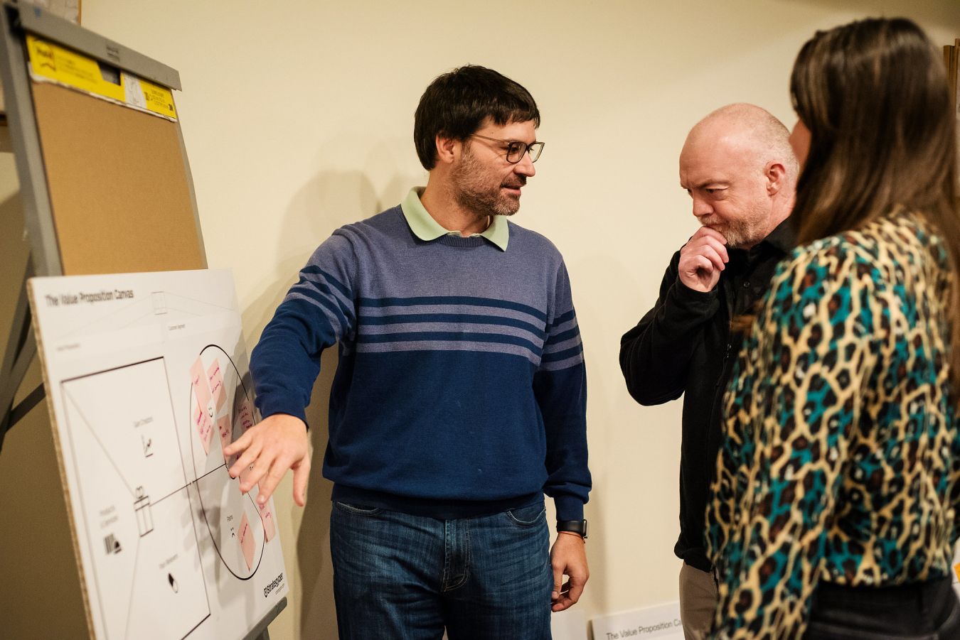 Three people discussing ideas around a whiteboard.