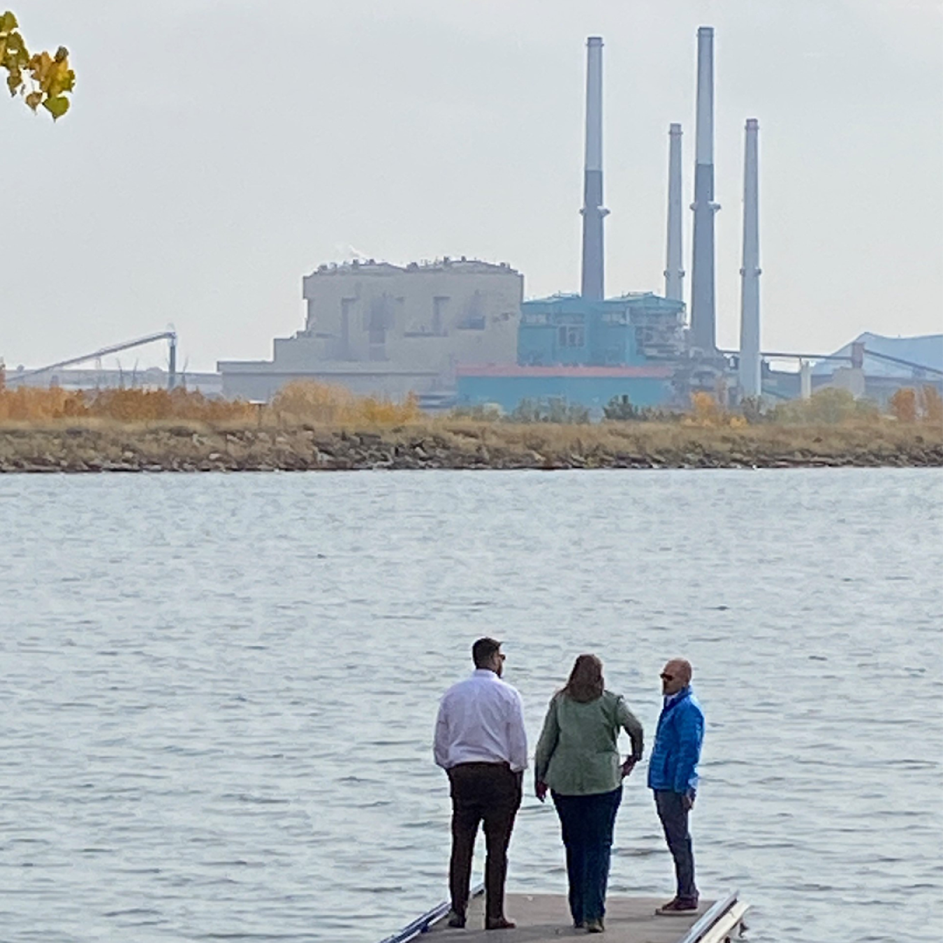 people look at a coal plant from a distance