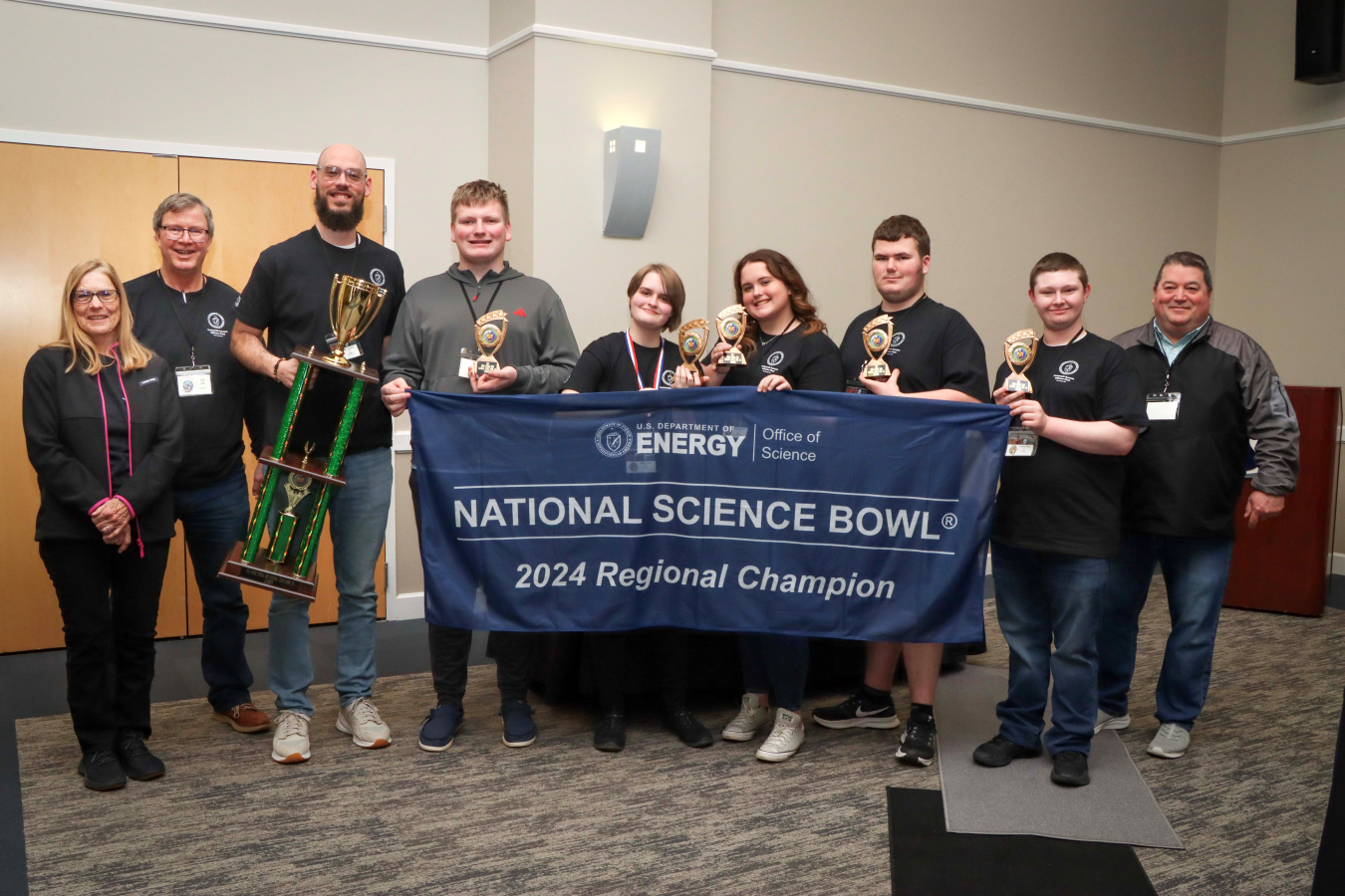 High school students pose with a science bowl banner