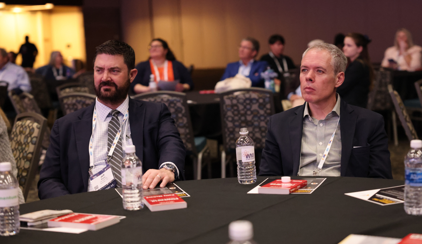 Two EM leaders sitting in the audience of a panel