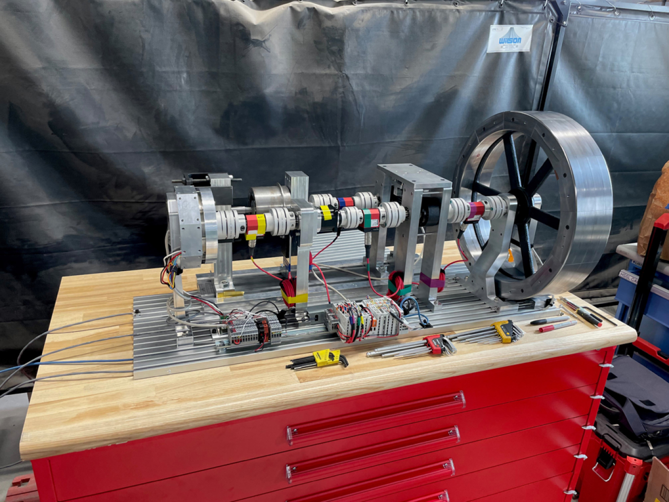 A photo of a flywheel mechanism on a work bench.