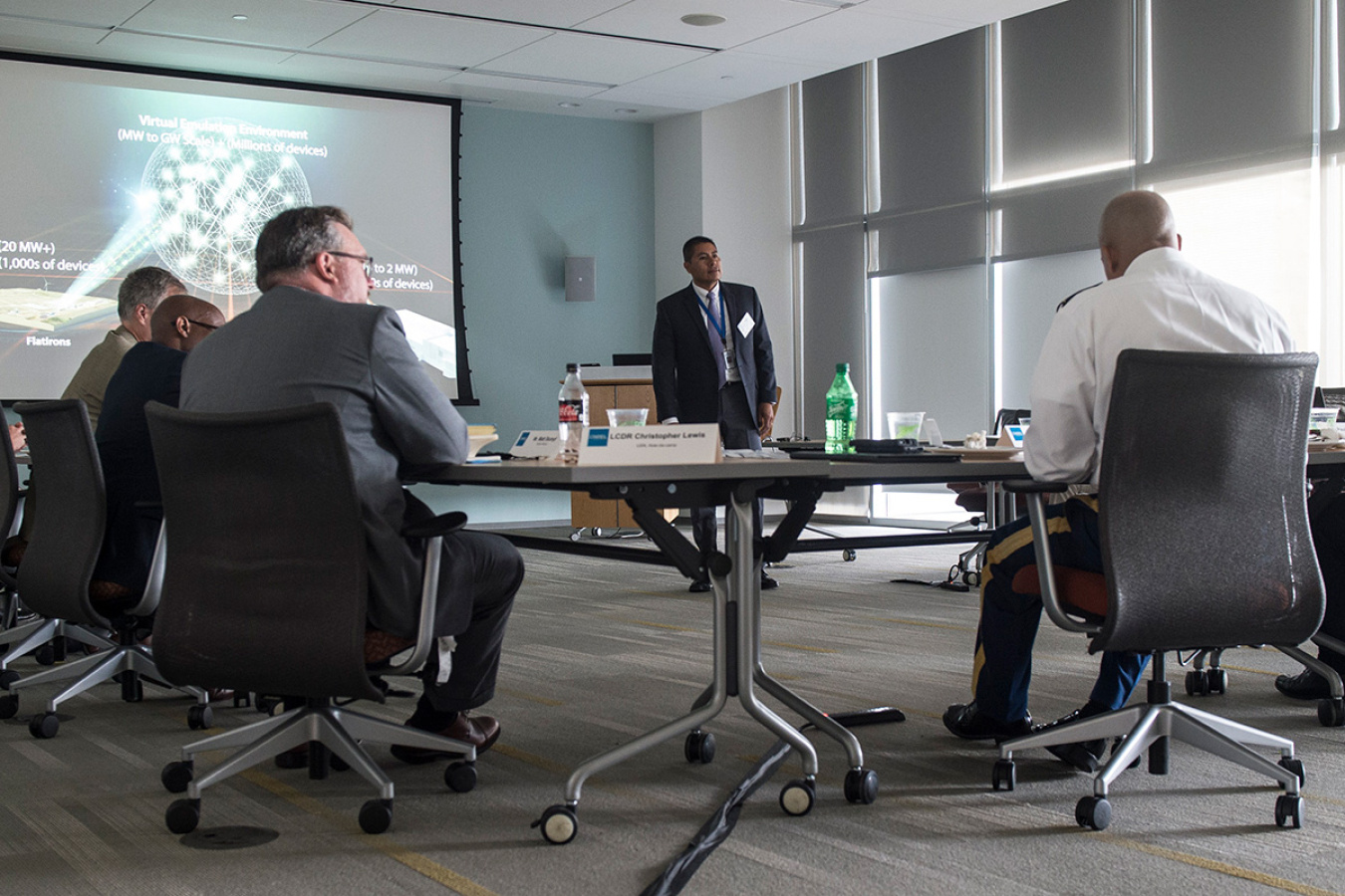 individuals sitting around a table listening to a presentation.