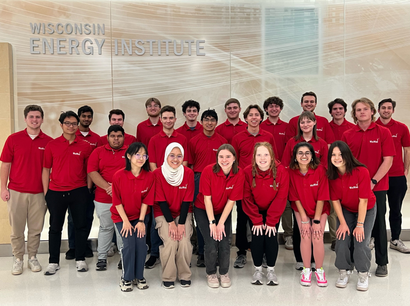 A group of people in front of a wall with a sign that reads, "Wisconsin Energy Institute."