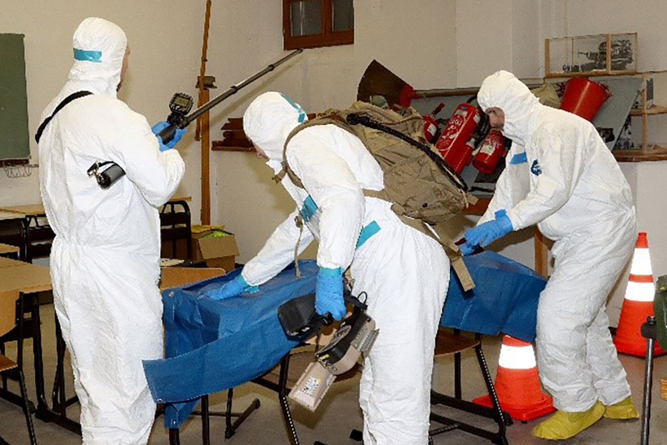 Three participants in the preparedness training in German donned protective suits before heading out.