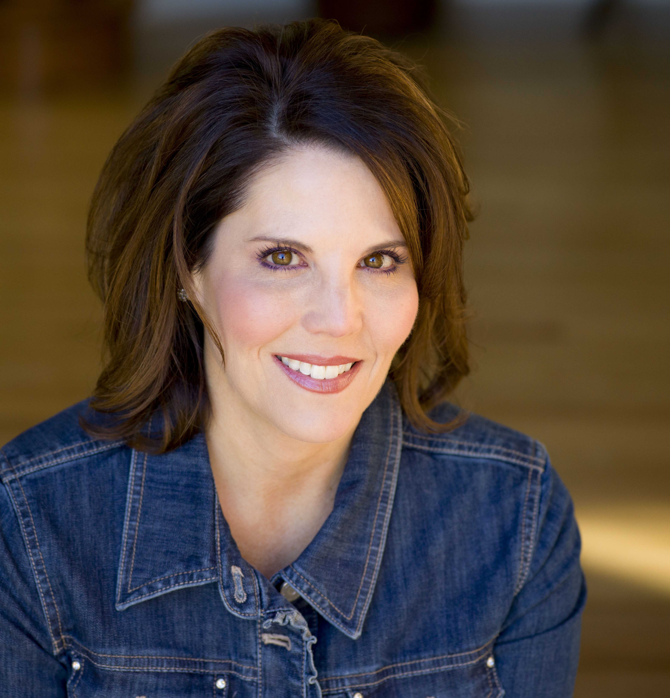 A headshot of a woman with dark short hair smiles for the camera.