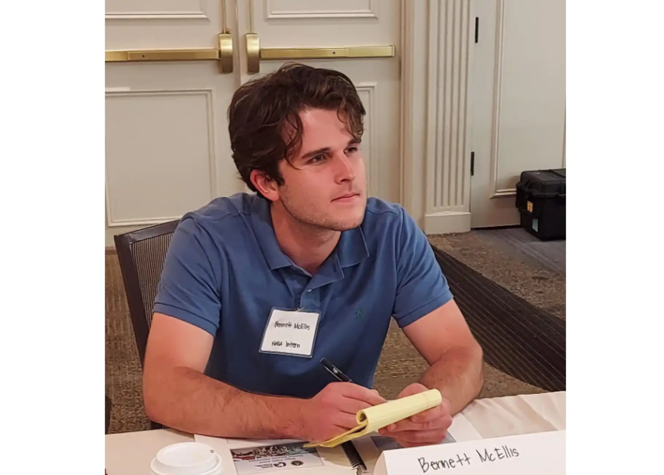 Bennett McEllis taking notes in a conference or meeting room
