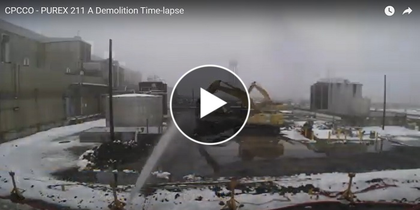 Still shot of a video of equipment vehicles demolishing with a play button over it