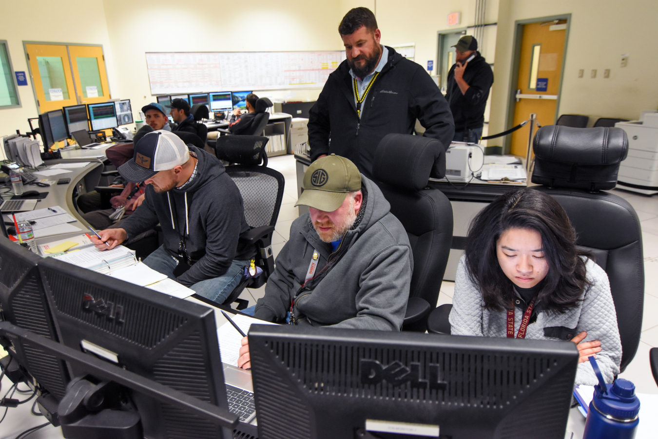 Employees sitting in front of computers in a control room