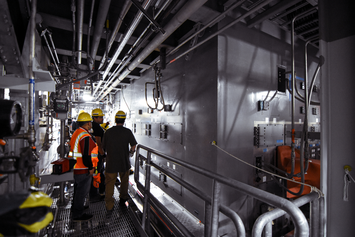 Workers inside a dark inside area of a melter