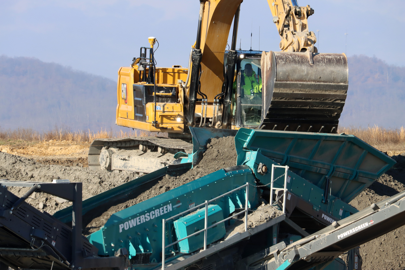Large construction vehicles moving dirt 