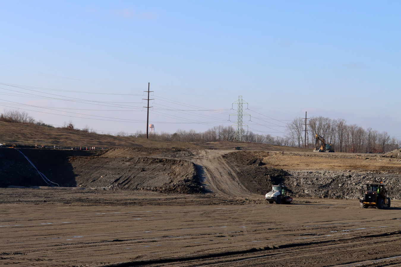 Large open disposal facility covered in dirt and rocks