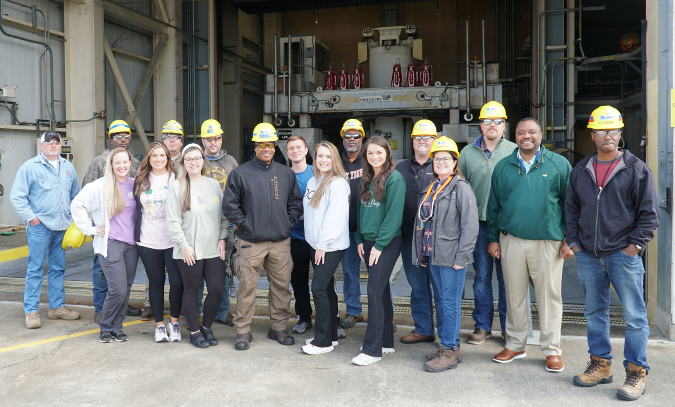 A group of individuals in hardhats pose for a picture