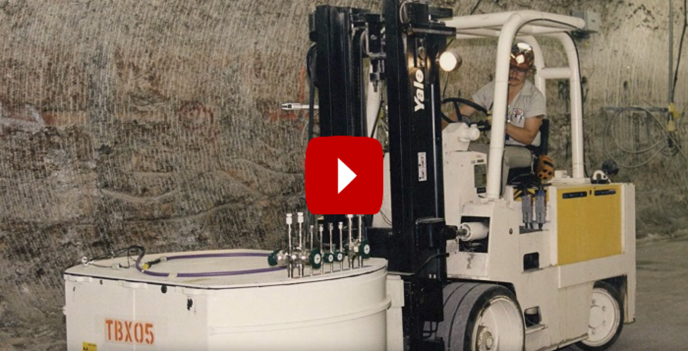 A screenshot of a video of a man operating a construction machine with a red and white play button over it