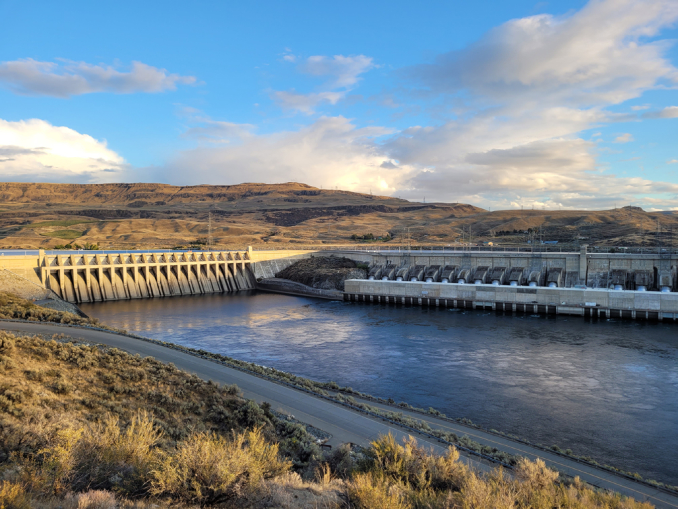 A view of a dam with a body of water in front of it.