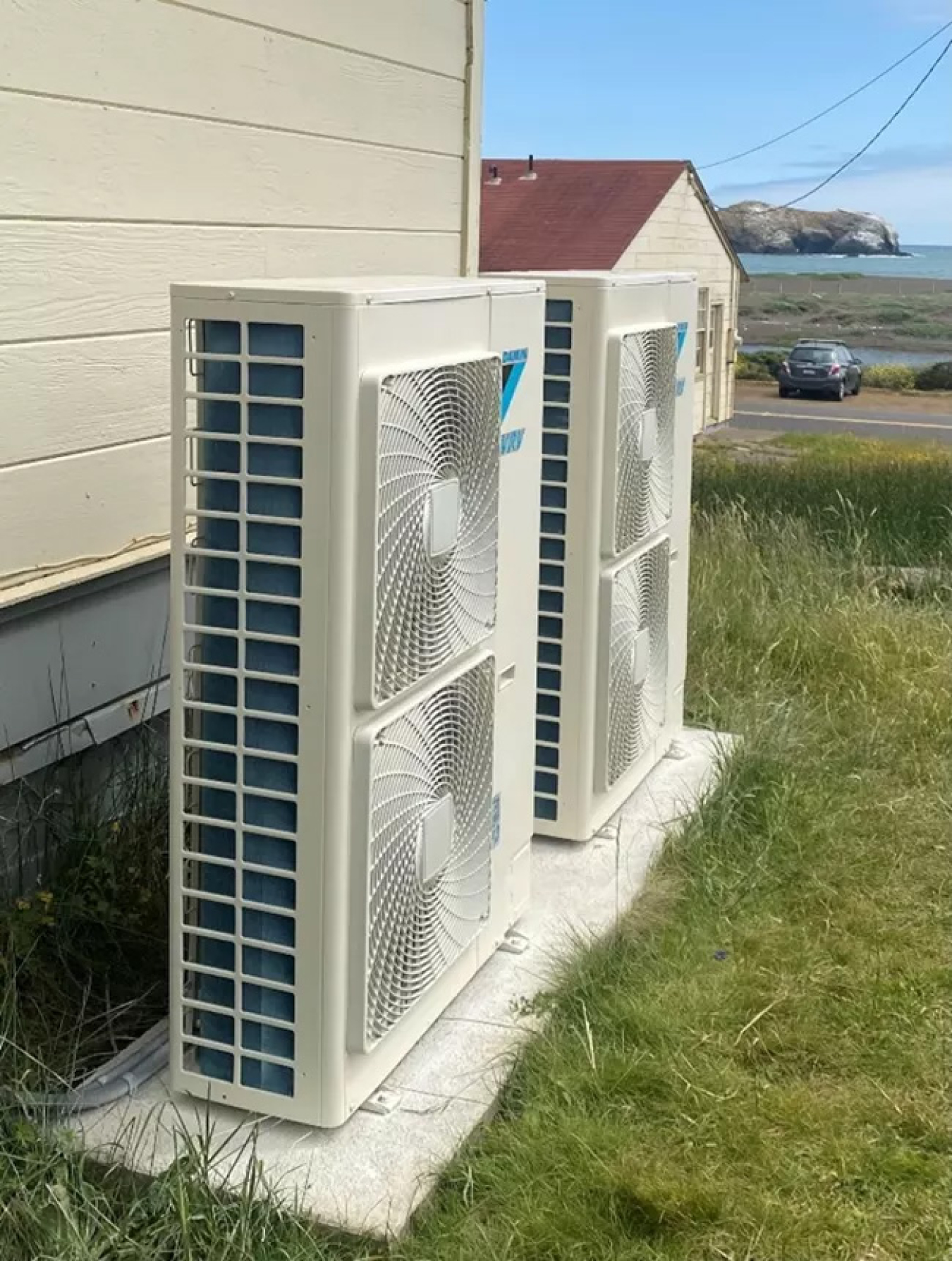 Close-up of two heat pumps outside a barracks building.