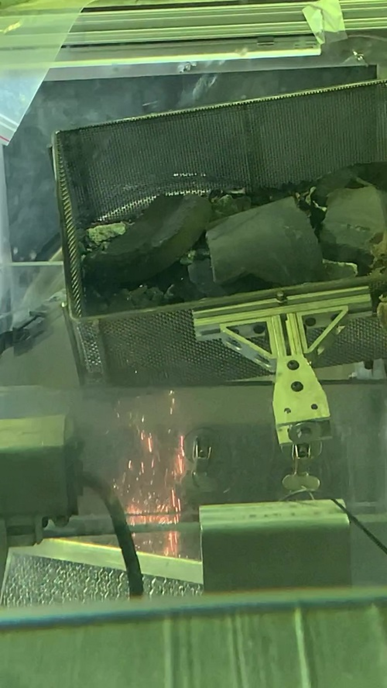 The inside view of a machine used to melt waste, a fire can be seen inside the machine