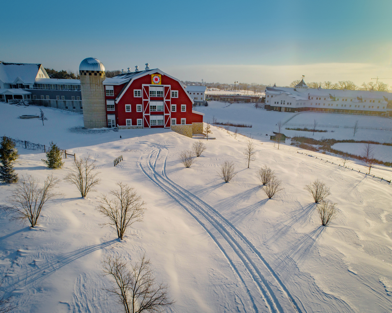 Snowy landscape with a red barn.